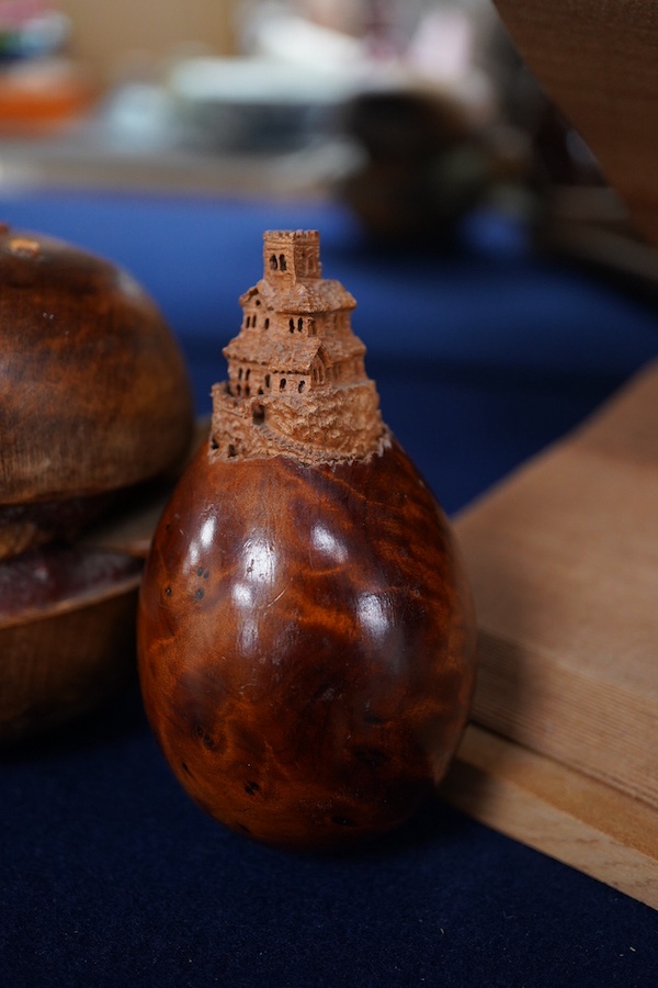 Pierre Decorse (b.1953), two carved wooden sculptures, an egg with a miniature town emanating from its top; and a stylised burger, largest 14cm wide